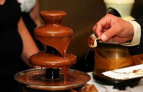 Chocolate flowing from a two-tier fountain setup.